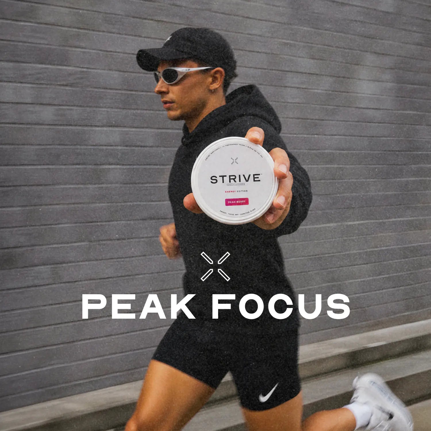 A runner in the rain holding a Peak-Berry tin out toward the camera mid-stride